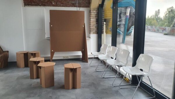 Sessel, Kartontische und (noch) leere Pinwand im DOCK