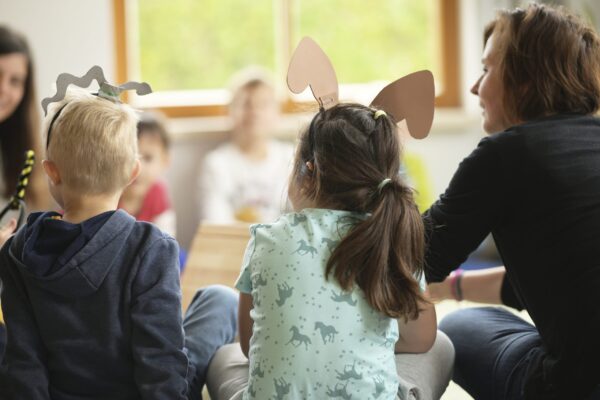 Kinder mit gebastelten Tierohren im Sitzkreis