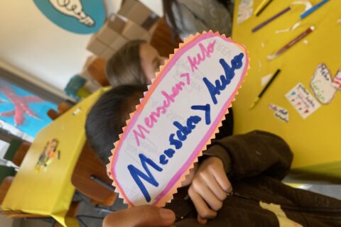 Kind mit Botschaft: Mensch > Auto
