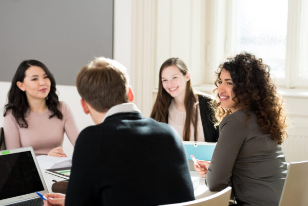 Junge Menschen sitzen am Tisch und diskutieren